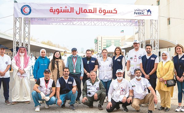 د.هلال الساير مع فريق بنك الكويت الوطني خلال تدشين حملة كسوة الشتاء