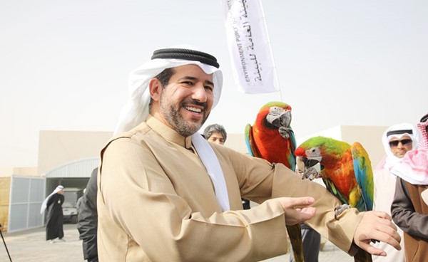 الشيخ عبد الله الأحمد حاملا أحد الطيور في المحمية