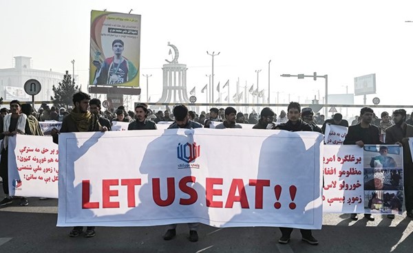 أفغان يرفعون لافتة كتب عليها دعونا نأكل خلال تظاهرة في كابول امس	(أ.ف.پ)