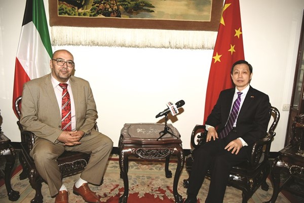سفير الصين لي مينغ قانغ والزميل أسامة دياب خلال اللقاء 	(قاسم باشا)