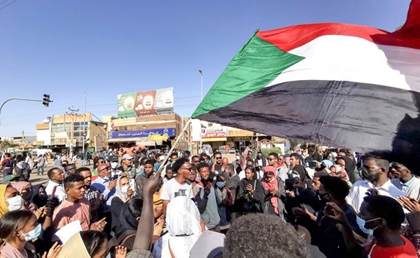سودانيون يلوحون بعلم بلادهم خلال احتجاجات ضد الحكم العسكري في الخرطوم امس 	 (ا.ف.پ)