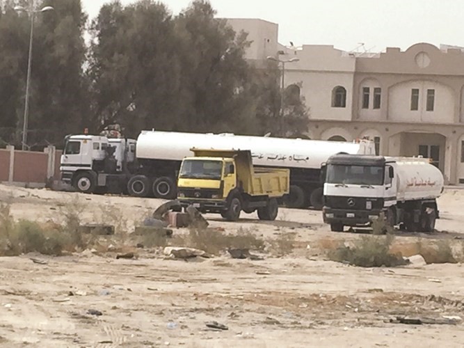 تناكر المياه بالقرب من البيوت في منطقة الجهراء
