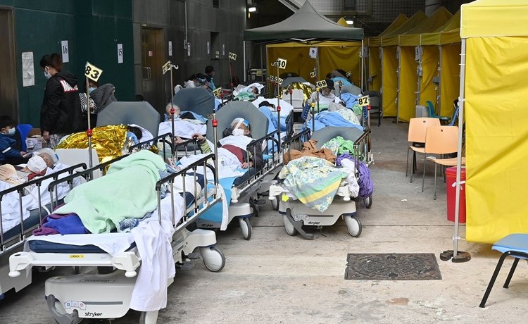 مصابون بـ كورونا يرقدون على أسرة خارج مركز كاريتاس الطبي نظرا لعدم وجود أماكن لهم في هونغ كونغ	(أ.ف.پ)