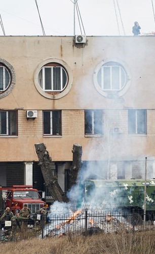 عسكريون يحاولون إخماد حريق خارج مبنى الاستخبارات التابعة لوزارة الدفاع الأوكرانية 	(رويترز)