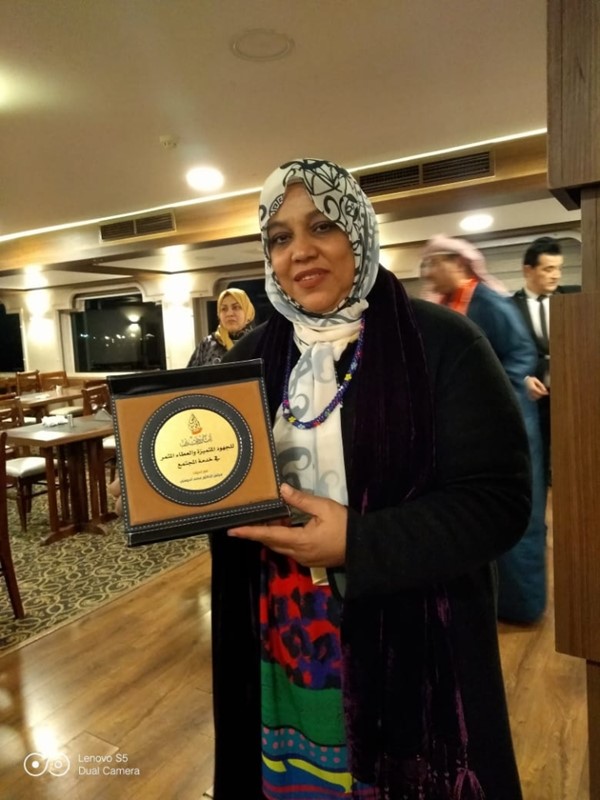 الزميلة هناء السيد مع درع التكريم
