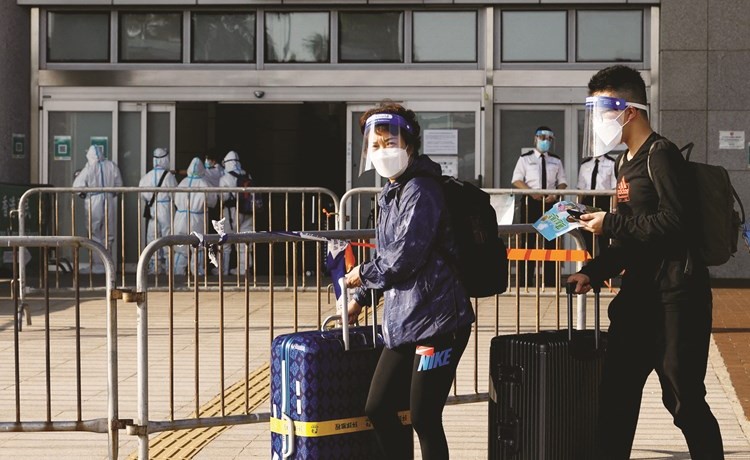 مسافران يرتديان كمامة الوجه للحماية من كورونا في هونغ كونغ أمس 	 (رويترز)