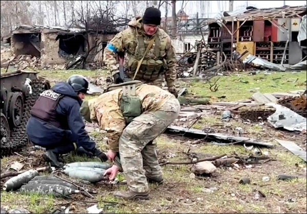 قوات اوكرانية تجمع مخلفات عسكرية تركتها القوات الروسية قبل انسحابها من مدينة بوتشا         (رويترز)