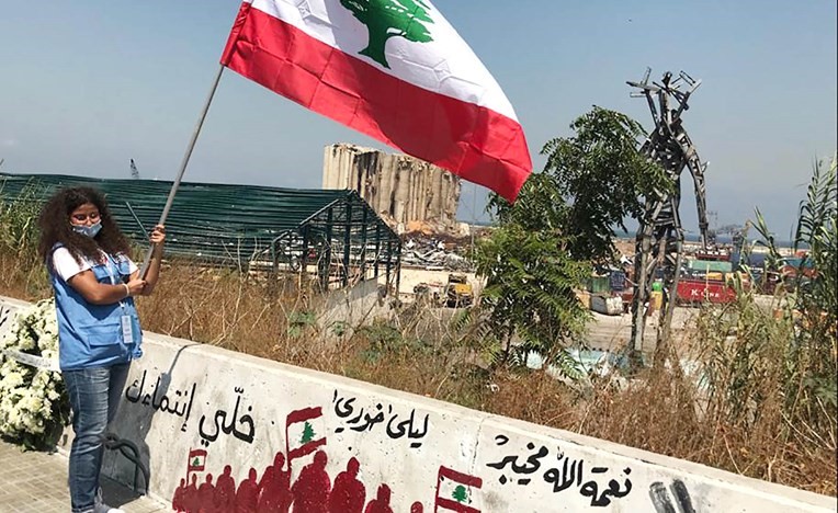لبنانية ترفع علم لبنان أمام مرفأ بيروت	(محمود الطويل)