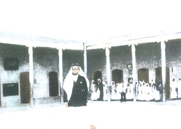 الأستاذ راشد السيف واقفا في ساحة المدرسة