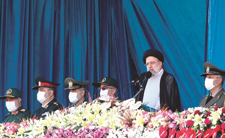 الرئيس الإيراني إبراهيم رئيسي خلال حضوره عرضا عسكريا (أ.ف.پ)