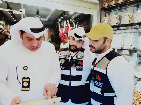 حامد الظفيري وخالد العبيدان ومحمد منصور يطلعون على تراخيص احد محلات بيع الورود والحلويات
