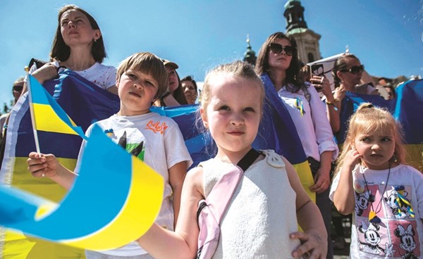 أطفال يحملون علم أوكرانيا خلال احتجاجات للاجئين في مدينة براغ بالتشيك		 ( أ.ف.پ)