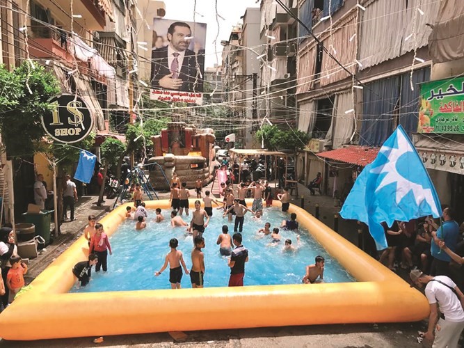 مناصرو الرئيس سعد الحريري خلال تركيب بركة سباحة للأولاد تعبيرا عن مقاطعتهم للانتخابات
