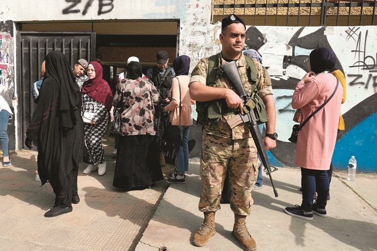 ناخبون يصطفون في طابور للإدلاء بأصواتهم في مركز اقتراع في مدينة طرابلس شمال لبنان (أ.ف.پ)