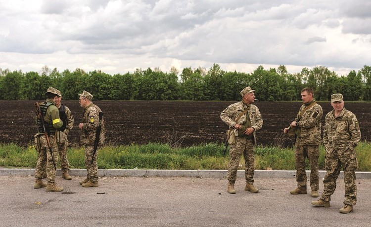 جنود أوكرانيون يقفون على أحد الطرق الرئيسية المؤدية إلى شرق البلاد أمس	(رويترز)