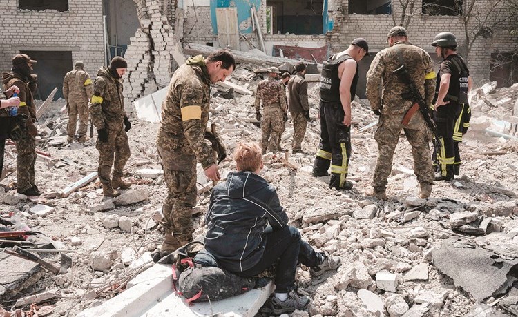 جنود أوكرانيون يحاولون العثور على أحياء وسط أنقاض مدرسة قصفت شرقي أوكرانيا		(أ.ف.پ)