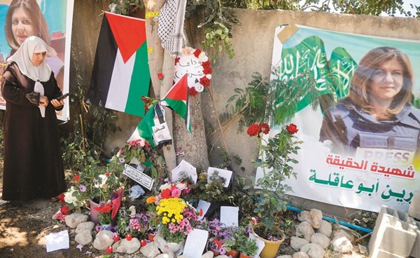 صور وأزهار في الموقع الذي اغتيلت فيه الإعلاميةشيرين أبو عاقلة في مخيم جنين	(رويترز)