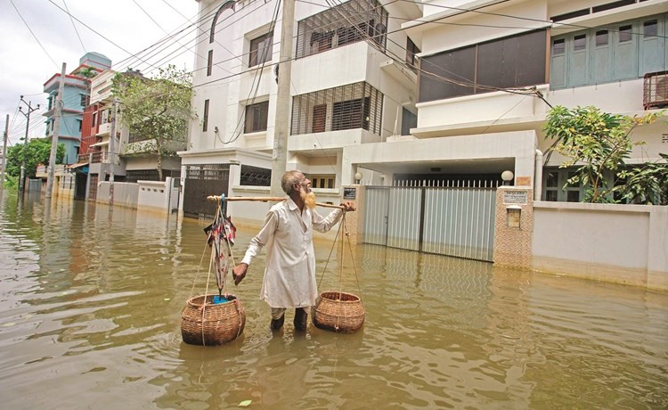 بائع بيض بنغالي يسوق بضاعته وسط مياه الفيضانات أمس(أ.ف.پ)