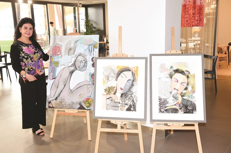 الفنانة زكية زادة مع لوحاتها