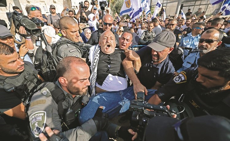 حرس الحدود الإسرائيلي يعتقل فلسطينيا خلال مسيرة الأعلام 	(أ.ف.پ)