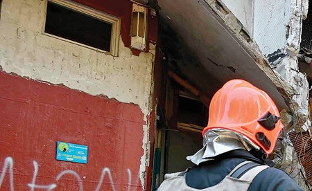 عمال الإنقاذ يفككون أنقاض مبنى سكني دمر جزئيا بسبب القصف الروسي في خاركيف (أ.ف.پ)