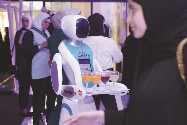 روبوت يقدم خدمات الضيافة للحاضرين