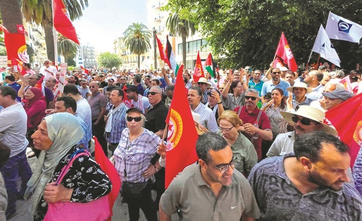 أنصار الاتحاد العام التونسي للشغل يحملون الأعلام خلال إضراب عام	 (رويترز)