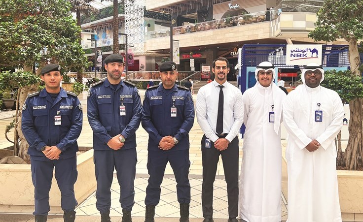 صورة تجمع فريق عمل بنك الكويت الوطني مع مسؤولي قوة الإطفاء العام