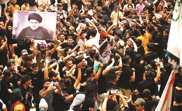 أنصار زعيم التيار الصدري يرفعون صورة له خلال اعتصامهم المتواصل في البرلمان العراقي أمس	(أ.ف.پ)