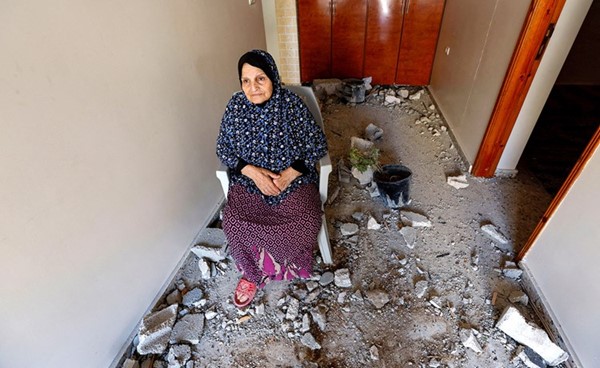 عجوز فلسطينية تختبئ في أحد الملاجئ بعد دمار منزلها في غارات الاحتلال أمس	(رويترز)