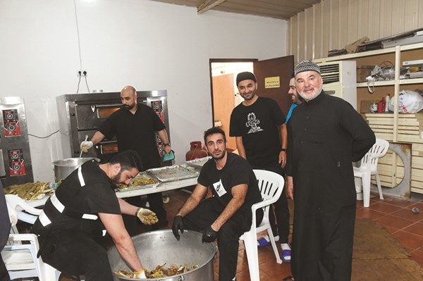 صالح عاشور متابعا عملية إعداد الوجبات في حسينية عاشور