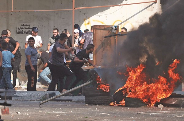  شبان فلسطينيون خلال مواجهات عنيفة مع قوات الاحتلال في نابلس أمس	 	(أ.ف.پ)