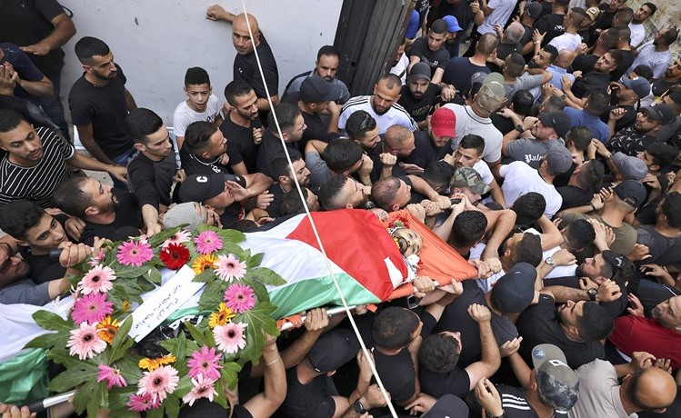 فلسطينيون يشيعون جثمان شاب لقي حتفه برصاص الاحتلال قرب القدس المحتلة امس	(أ.ف.پ)
