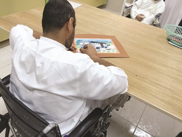 نزيل يمارس هواية الرسم في احدى الورش التدريبية للمعاقين
