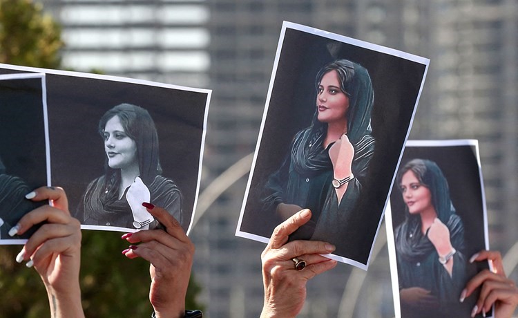 نساء يحملن صور مهسا أميني التي أججت وفاتها وهي رهن الاعتقال احتجاجات عارمة في ايران		(أ.ف.پ)