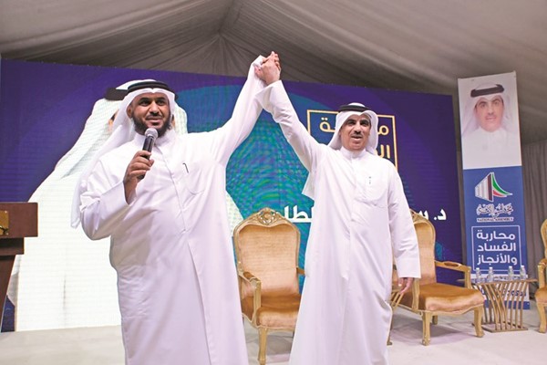 المرشح محمد خليفة العازمي يرفع يد د.سعود الطامي