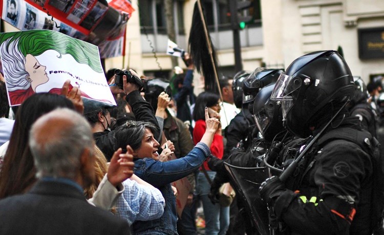 شرطة مكافحة الشغب الفرنسية في مواجهة المتظاهرين لدعم الاحتجاجات الايرانية (أ.ف.پ)