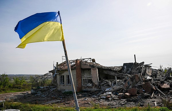 العلم الأوكراني يرفرف أمام الدمار في مدينة ايزيوم التي تحررت قبل ايام (أ.ف.پ)