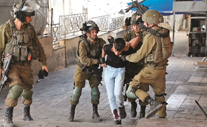 قوات الاحتلال الإسرائيلي تعتقل شابا فلسطينيا عقب اشتباكات في مدينة الخليل أمس	(أ.ف.پ)