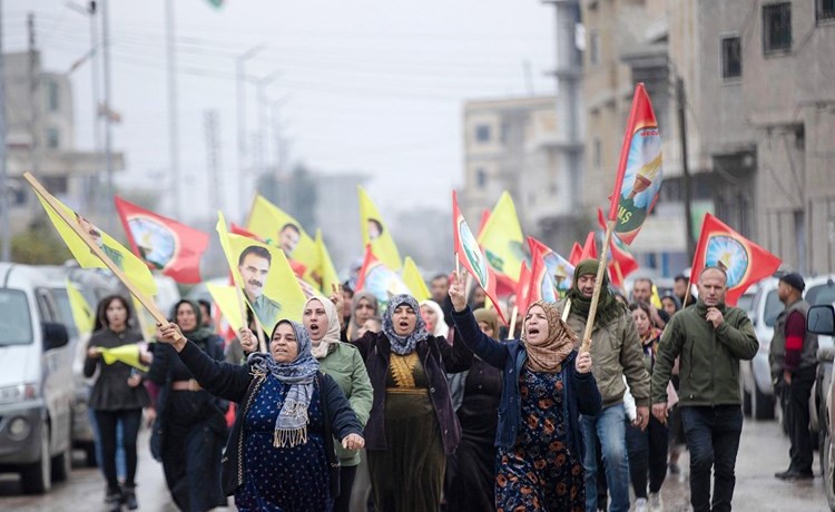 محتجون أكراد يرفعون علم وصور زعيم حزب العمال الكردستاني عبدالله أوجلان في عين العرب (كوباني) (أ.ف.پ)
