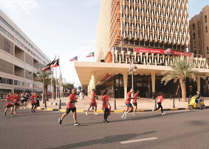 مجموعة من المتسابقين يمرون أمام المبنى الرئيسي لبنك الخليج ضمن مسار السباق	(أحمد علي)