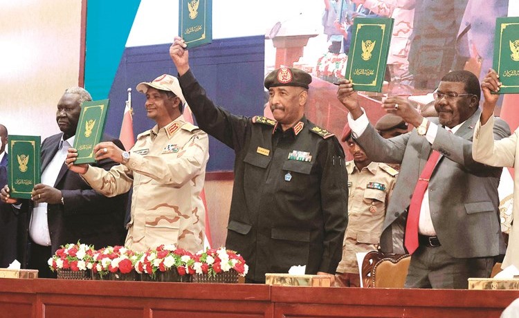 قادة الجيش والقادة المدنيون يرفعون نسخا من الاتفاق بعد التوقيع	(أ.ف.پ)
