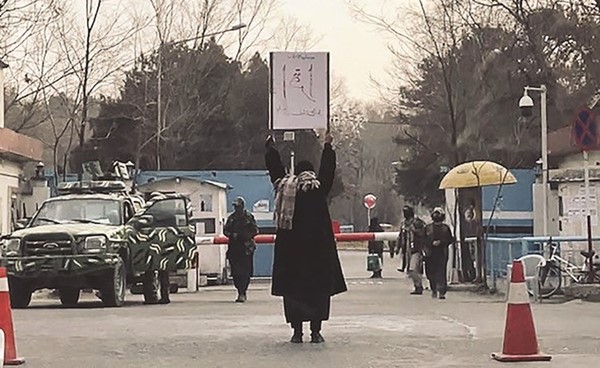 الطالبة مروة تتحدى طالبان وتحتج بمفردها على منع دخول الفتيات للجامعات وتحمل لافتة كتب عليها اقرأ (أ.ف.پ)