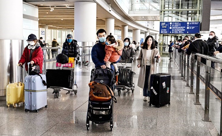 مسافرون في صالة الوصول بمطار بكين الدولي في أول أيام رفع الحجر الصحي الإلزامي أمس (أ.ف.پ)