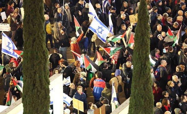 إسرائيليون يلوحون بعلم فلسطين خلال تظاهرة في تل أبيب ضد حكومة نتنياهو اليمينية المتطرفة (أ.ف.پ)
