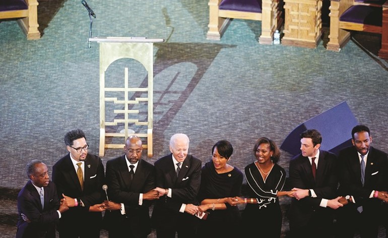 الرئيس الأميركي جو بايدن في صورة جماعية خلال مشاركته في الاحتفال بذكرى مارتن لوثر كينغ (رويترز)