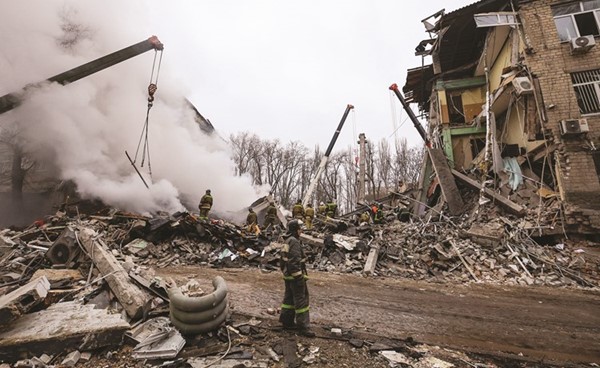 موظفو الطوارئ وسط أنقاض مبنى تضرر من القصف الروسي في دونيتسك 	(رويترز)