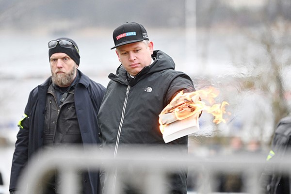 السياسي الدانماركي اليميني المتطرف راسموس بالودان يحرق نسخة من القرآن امام السفارة التركية في ستوكهولم (رويترز)
