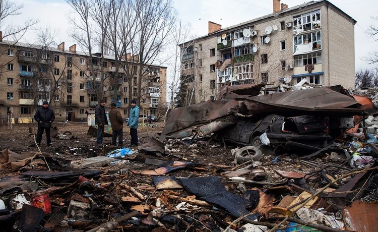 أوكرانيون بجانب موقع تعرض لهجوم صاروخي روسي في كوستيانتينيفكا (رويترز)
