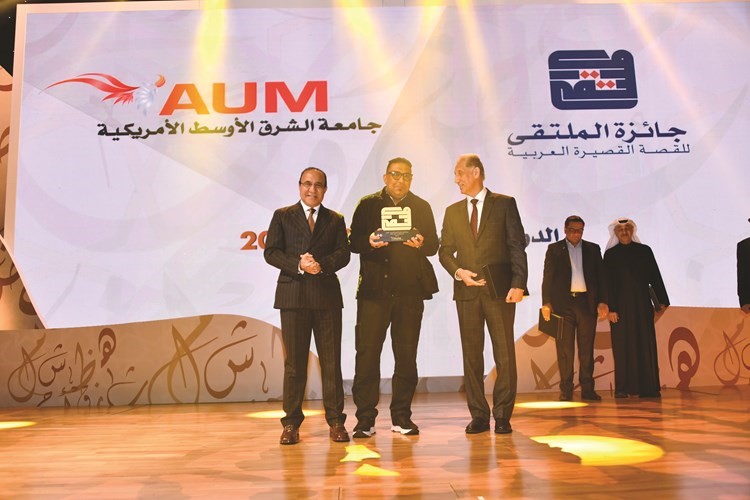 فهد العثمان والأديب طالب الرفاعي يسلمان الكاتب المغربي أنيس الرافعي جائزة الملتقى	(زين علام)